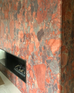 Rivestimento di un camino in granito Marinage Rosso