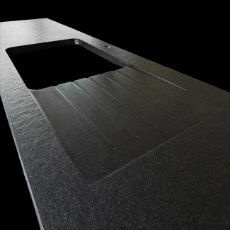 Piano cucina in granito Nero Assoluto fiammato e spazzolato con gocciolatoio realizzato da gusce e scivolo levigate.